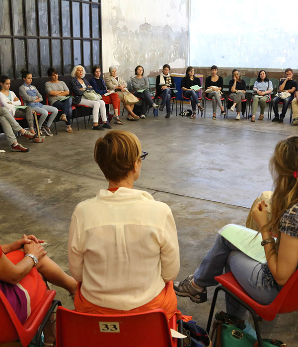 Participants of Migrant Bodies sit in a circle in the middle of a conversation