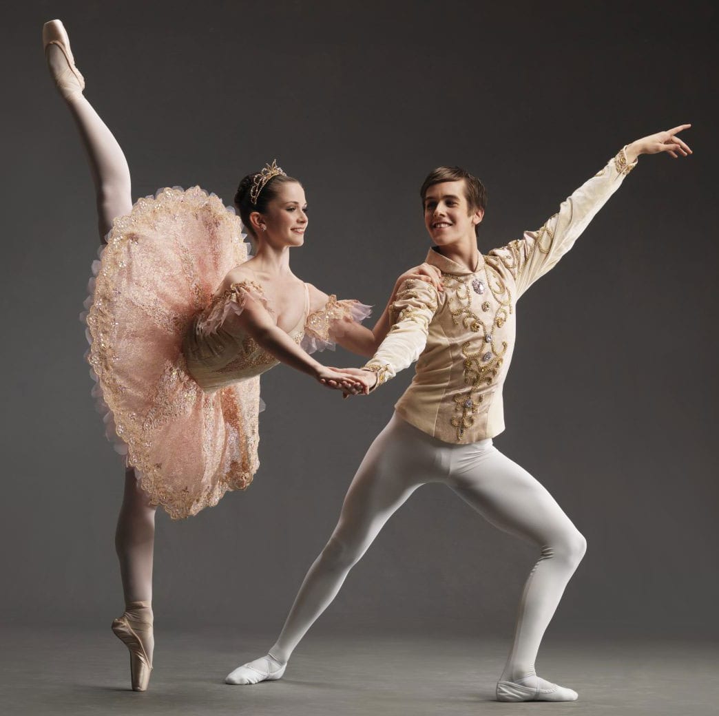 Two ballet dancers pose in full ballet costumes