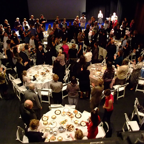 People stand around tables at an event in the Faris Family Studio
