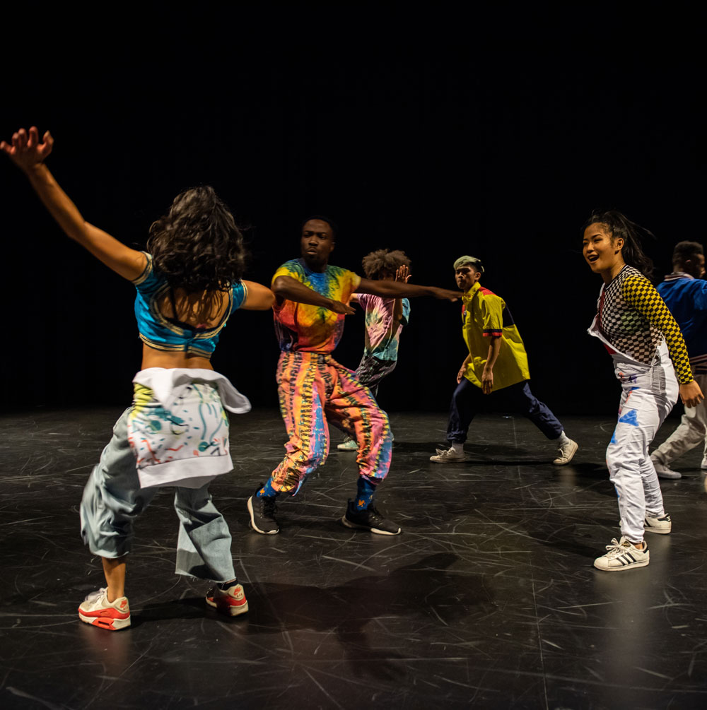 Dance artists from Immigrant Lessons pose mid performance