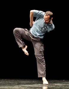 Dance artist Hillel Kogan poses mid performance