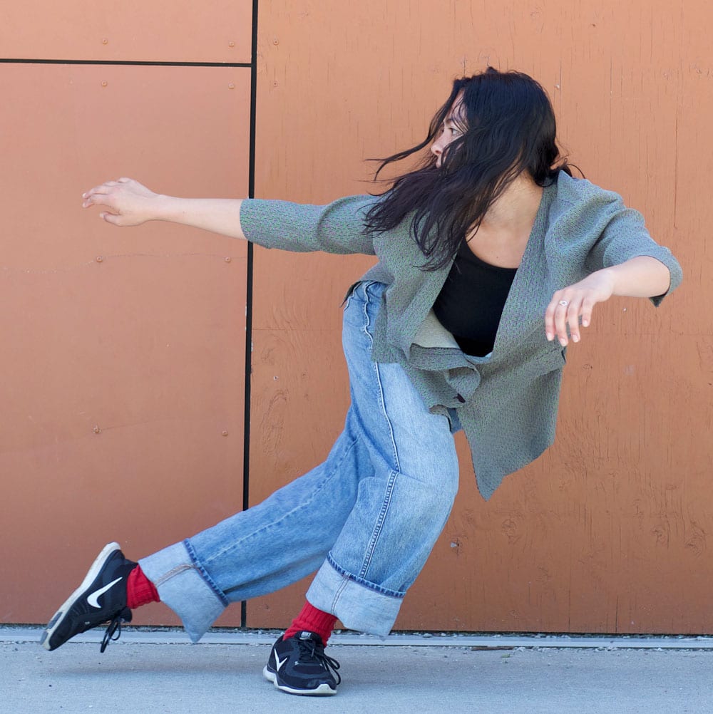 Dance artist Shana Wolfe poses mid side lunge with arms out