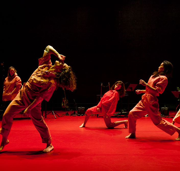 Four female dance artists pose on stage mid lunge.