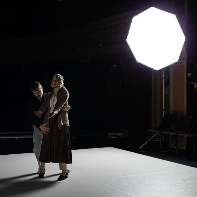 Dance artists Maria Nurmela and Ville Oinonen grasp each other mid performance